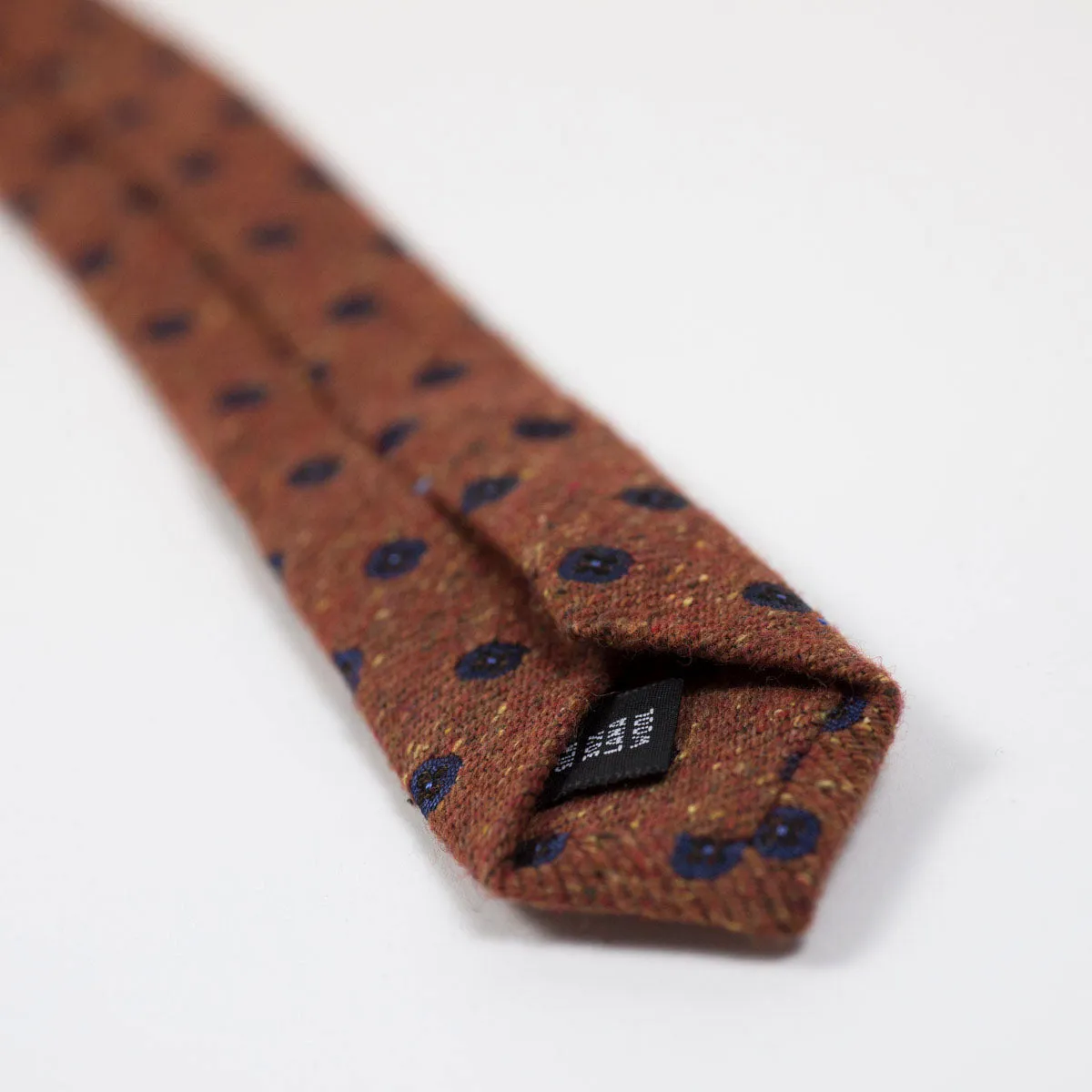 Rust silk and wool donegal tie, navy neat motifs